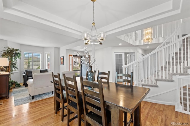 16862 W 65th Cir, Arvada, CO 80007 - dining space featuring a chandelier, a tray ceiling, light wood-type flooring, stairs, and recessed lighting