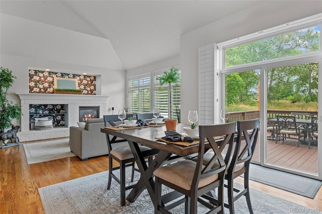 16862 W 65th Cir, Arvada, CO 80007 - dining area with lofted ceiling, a brick fireplace, and wood finished floors