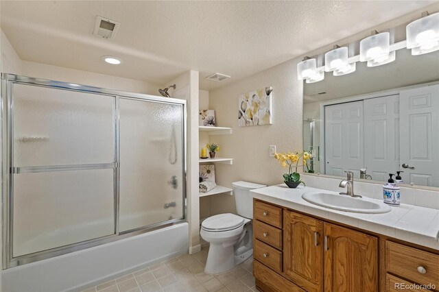 16862 W 65th Cir, Arvada, CO 80007 - bathroom with vanity, tile patterned floors, shower / bath combination with glass door, a textured ceiling, and recessed lighting