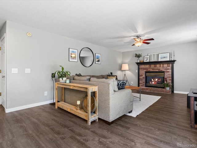 20789 E Princeton Pl, Aurora, CO 80013 - living area featuring dark wood-style floors, a ceiling fan, a fireplace, and baseboards