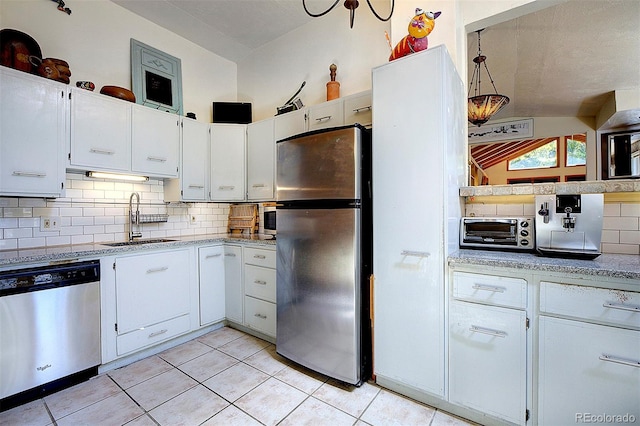 kitchen featuring stainless steel appliances, sink, decorative backsplash, and white cabinets