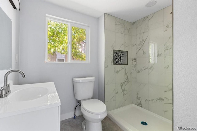 bathroom with a tile shower, vanity, and toilet