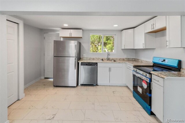 kitchen with white cabinets, light stone counters, sink, and stainless steel appliances