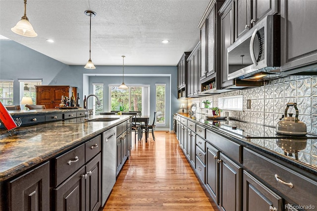 kitchen featuring pendant lighting, stainless steel appliances, and dark brown cabinets