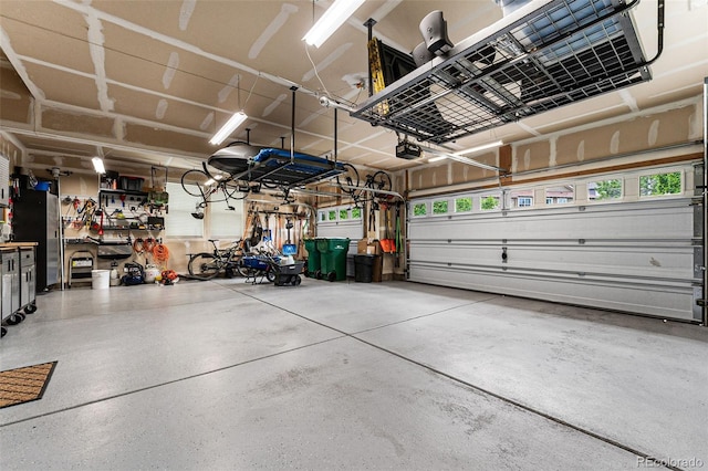 garage featuring a garage door opener and stainless steel refrigerator