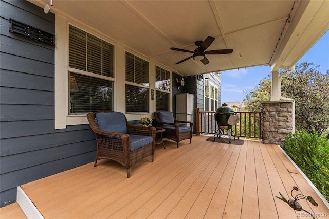 deck with grilling area and ceiling fan