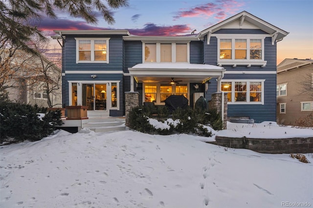 snow covered house featuring ceiling fan