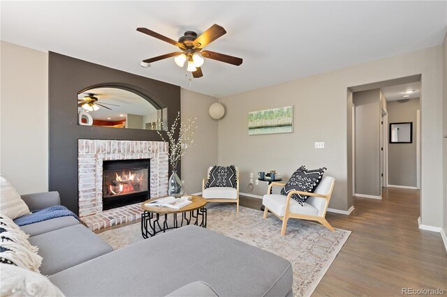 2043 Fendlebrush St, Highlands Ranch, CO 80129 - living area with ceiling fan, wood finished floors, baseboards, and a brick fireplace