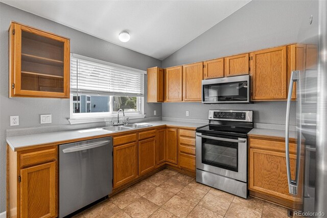 kitchen featuring sink, stainless steel appliances, lofted ceiling, and light tile patterned floors