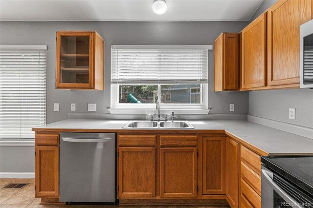 kitchen featuring sink, stainless steel dishwasher, and light tile patterned floors