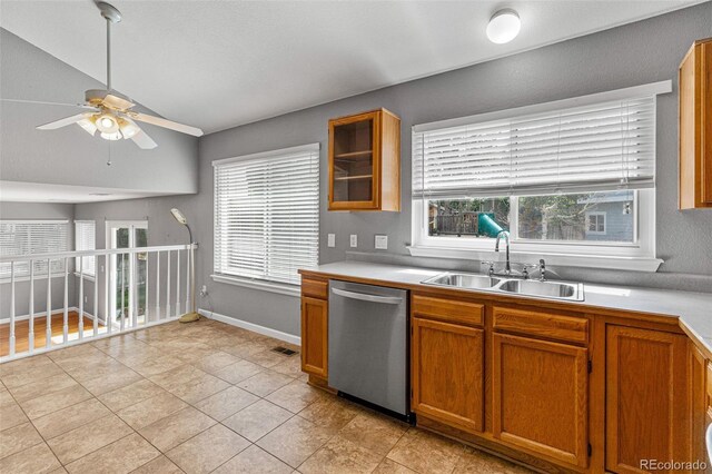 kitchen with ceiling fan, stainless steel dishwasher, vaulted ceiling, light tile patterned floors, and sink