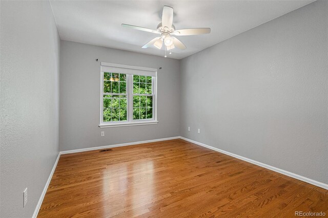 empty room with ceiling fan and light hardwood / wood-style floors