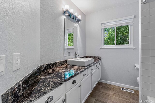 bathroom with tile patterned flooring, toilet, and vanity