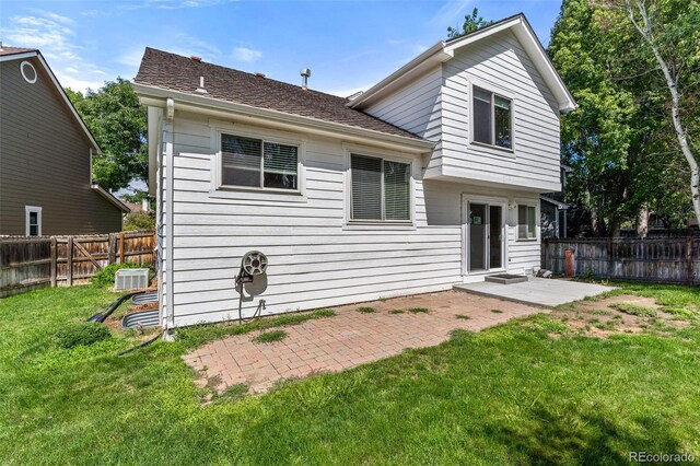 back of house featuring a patio and a yard