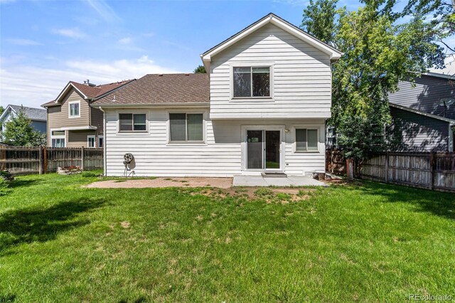 rear view of property featuring a lawn