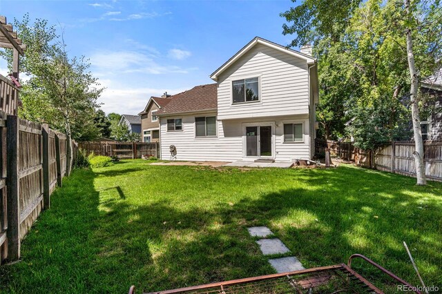 rear view of house featuring a yard