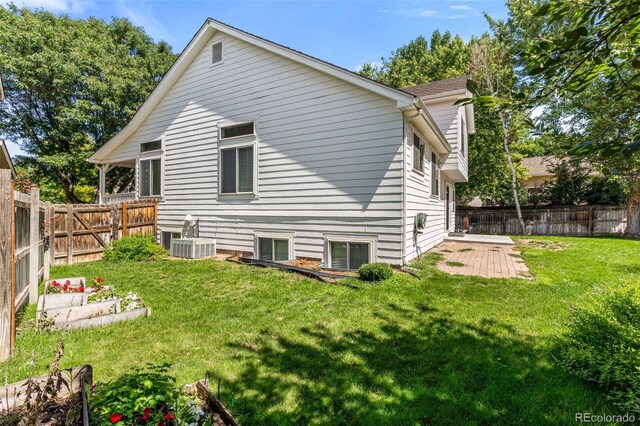 back of property featuring central AC unit, a patio, and a yard