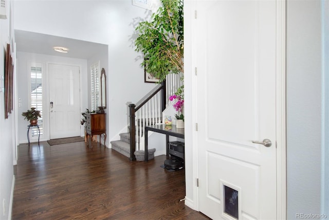 foyer featuring stairs, dark wood-type flooring, and baseboards