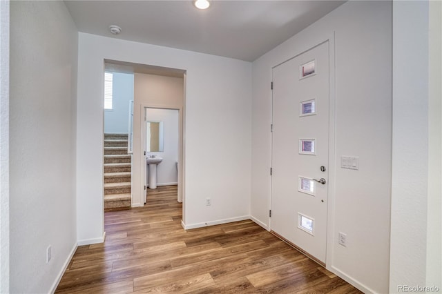 foyer entrance with light hardwood / wood-style floors and sink