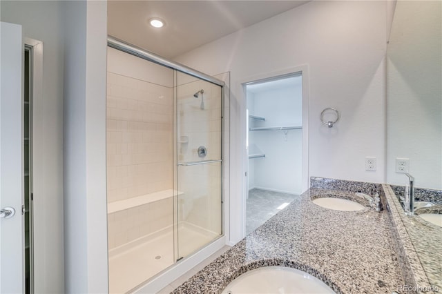 bathroom featuring vanity and a shower with door