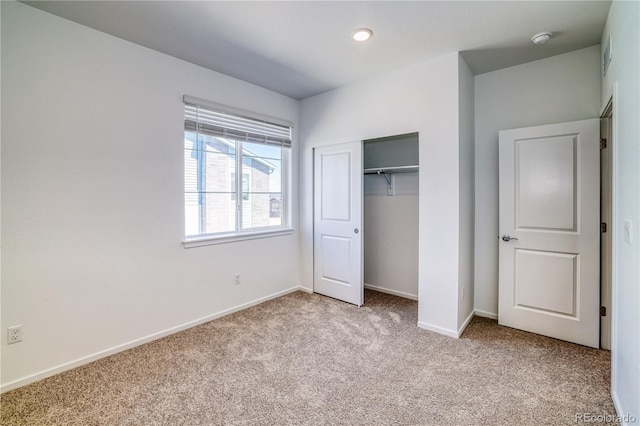 unfurnished bedroom with light carpet and a closet