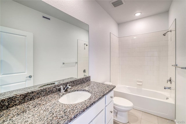 full bathroom with tile patterned floors, vanity, tiled shower / bath combo, and toilet