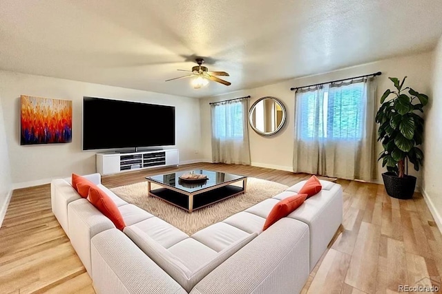 living area with ceiling fan, wood finished floors, and baseboards