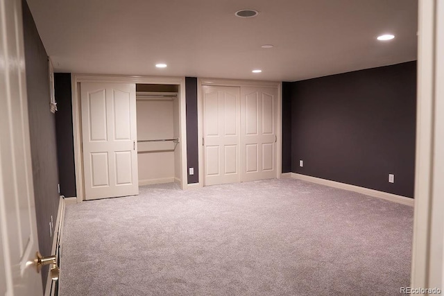 unfurnished bedroom featuring multiple closets, carpet, recessed lighting, and baseboards