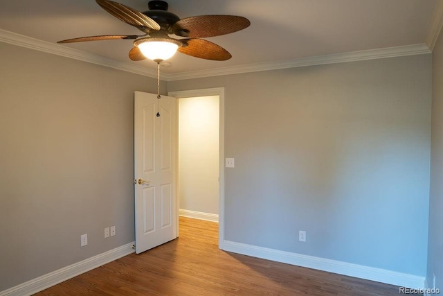 empty room with ceiling fan, baseboards, ornamental molding, and wood finished floors
