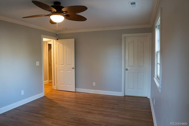 spare room with ceiling fan, baseboards, wood finished floors, and crown molding