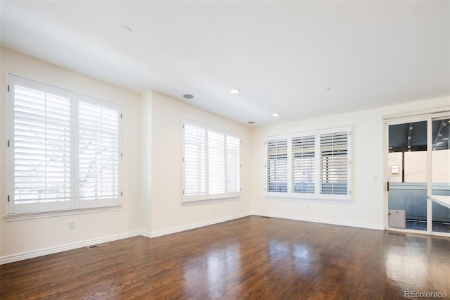 unfurnished room featuring dark hardwood / wood-style flooring and plenty of natural light