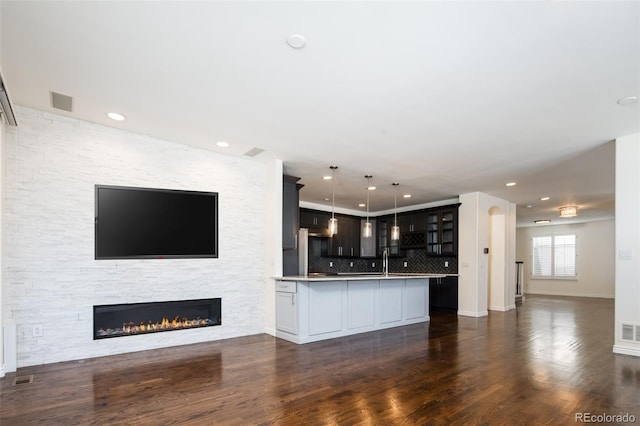 unfurnished living room featuring a fireplace, dark hardwood / wood-style flooring, and sink