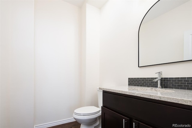 bathroom with vanity, toilet, and wood-type flooring