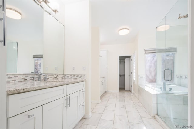 bathroom with tasteful backsplash, vanity, and independent shower and bath