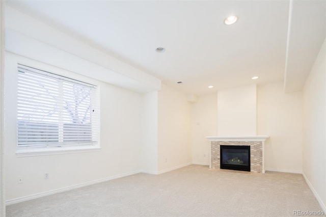 unfurnished living room with light carpet and a tile fireplace