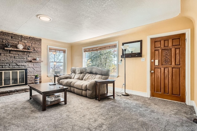 carpeted living room featuring a fireplace and a textured ceiling