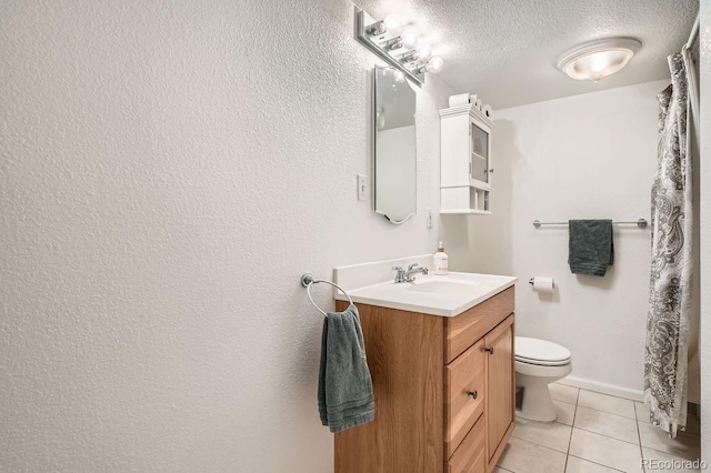 bathroom featuring tile patterned floors, vanity, a textured ceiling, and toilet