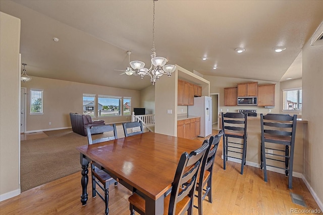 dining room featuring light hardwood / wood-style flooring, a healthy amount of sunlight, and lofted ceiling