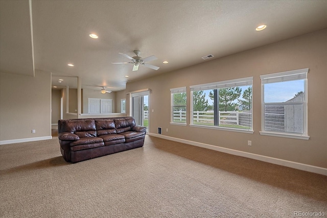 carpeted living room with ceiling fan