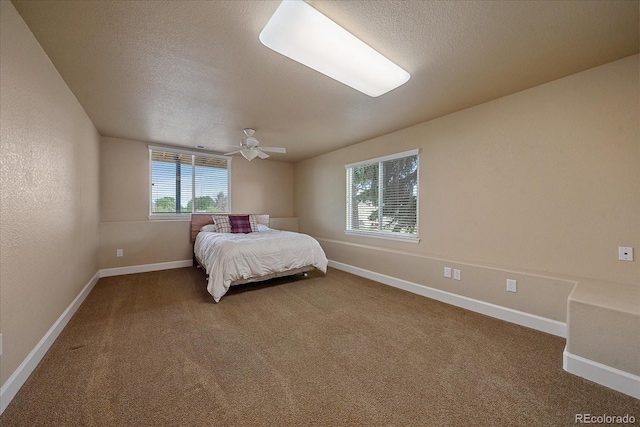 carpeted bedroom featuring multiple windows, ceiling fan, and a textured ceiling