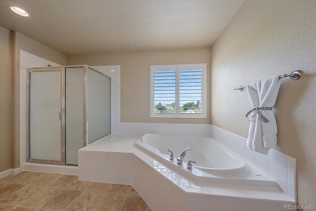 bathroom with separate shower and tub and a textured ceiling