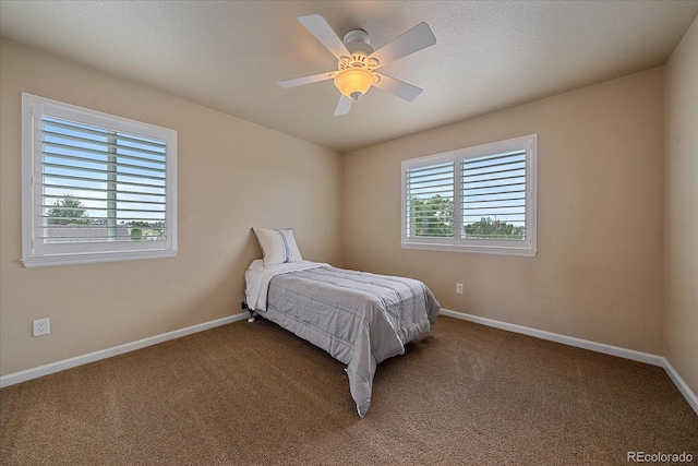 carpeted bedroom featuring ceiling fan and multiple windows