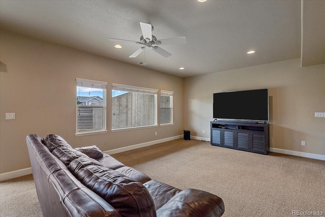 living room with ceiling fan, light colored carpet, and a textured ceiling