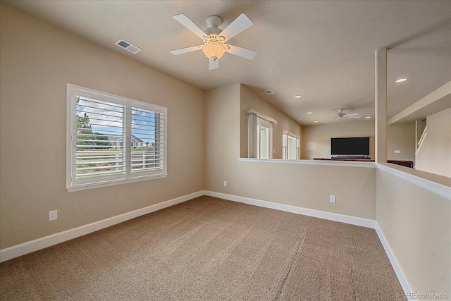 carpeted spare room featuring ceiling fan