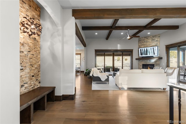 living room with beam ceiling, a fireplace, recessed lighting, a ceiling fan, and wood finished floors