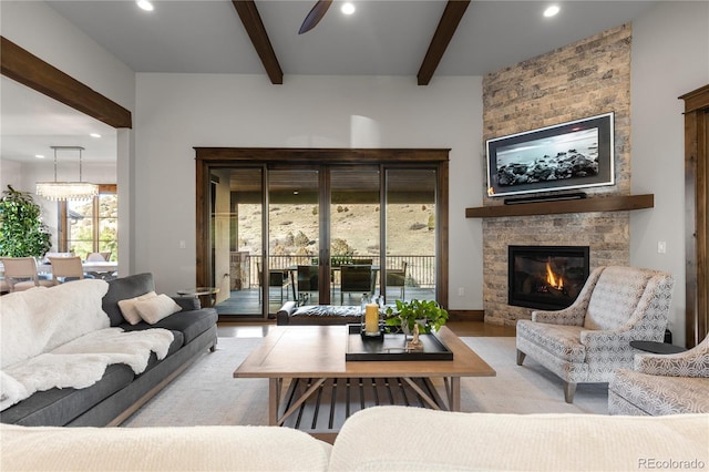 living room with recessed lighting, ceiling fan, beamed ceiling, and a stone fireplace