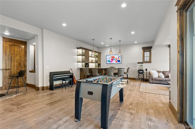 recreation room with a dry bar, light wood finished floors, baseboards, and recessed lighting