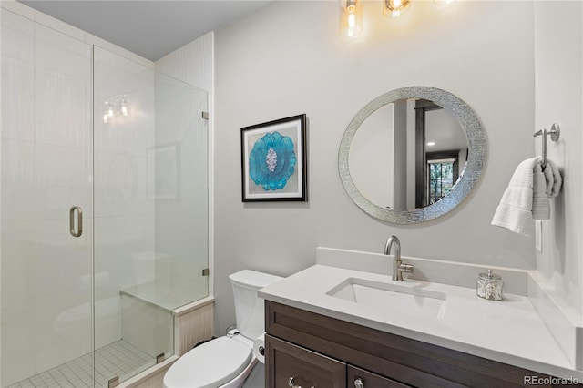 bathroom with a stall shower, vanity, and toilet