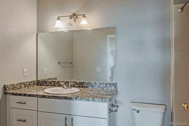 14251 E 1st Dr Unit 308, Aurora, CO 80011 - bathroom featuring toilet, vanity, and a shower