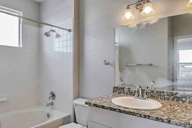 14251 E 1st Dr Unit 308, Aurora, CO 80011 - full bathroom featuring healthy amount of natural light, toilet, vanity, bathing tub / shower combination, and a textured wall
